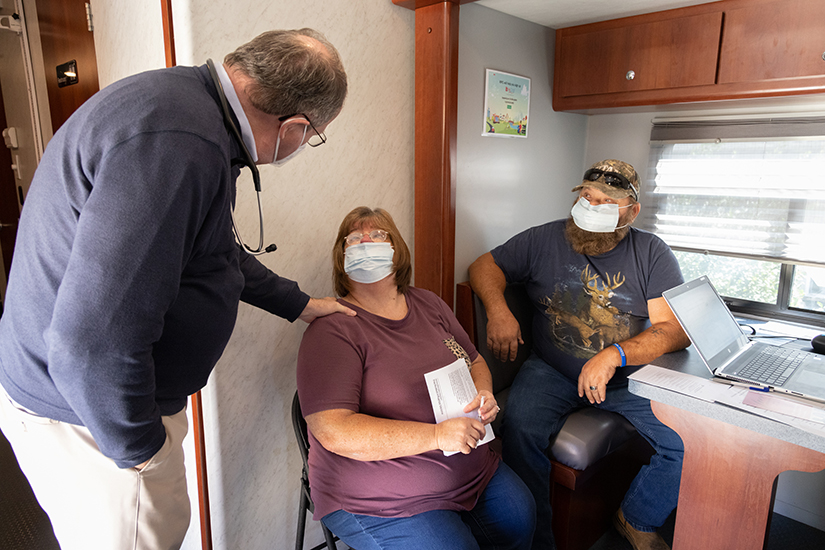 Dr. William Guyol, left, talked with Carla Akers and her husband, Steve Akers, after a medical examination in the Rural Parish Clinic medical van on Sept. 26 at St. Joachim Church in Old Mines. Dr. Guyol has been volunteering medical services at the clinic since he retired from his practice.