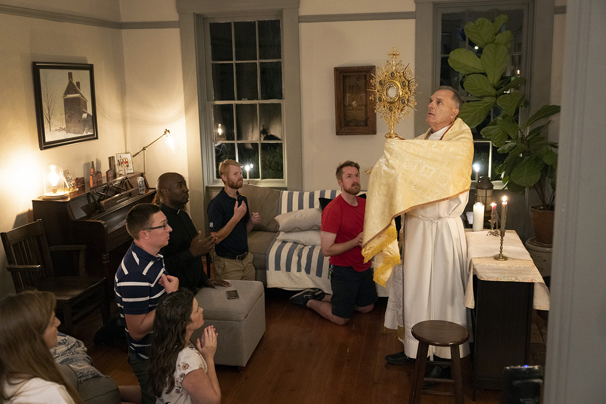 Deacon John Heithaus from Sacred Heart Parish in Florissant elevated a monstrance containing the Eucharist during
Benediction at a formation gathering Aug. 6 at the home of Theresa and Lucian Matoushek in Florissant.