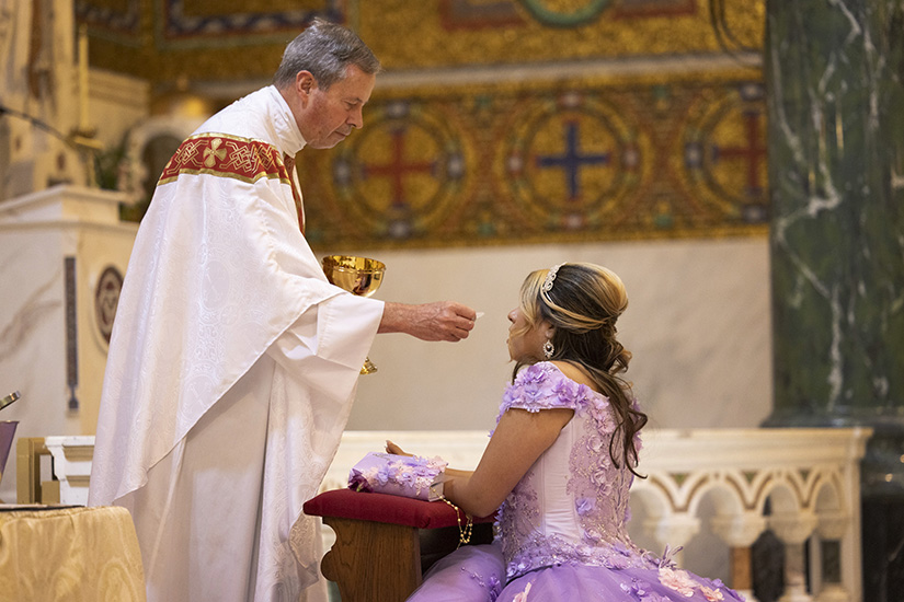 Andrea Islas-Gasca, a parishioner at St. Cecilia Parish, received Communion from Father James Michler at her quinceañera Mass Aug. 13 at St. Cecilia Church in St. Louis.
