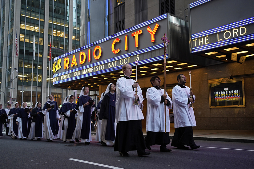 Seminarians led a eucharistic procession as it passed Radio City Music Hall in New York City Oct. 11. The procession, which followed Mass at Sacred Heart of Jesus Church and traveled a mile-long route through Midtown Manhattan, concluded at St. Patrick’s Cathedral, where New York Cardinal Timothy M. Dolan led Benediction.