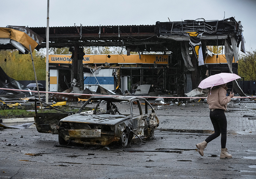 A woman passed by a gas station destroyed by a Russian military strike Oct. 26. Much of Ukraine’s water and heating infrastructure has been damaged or destroyed.