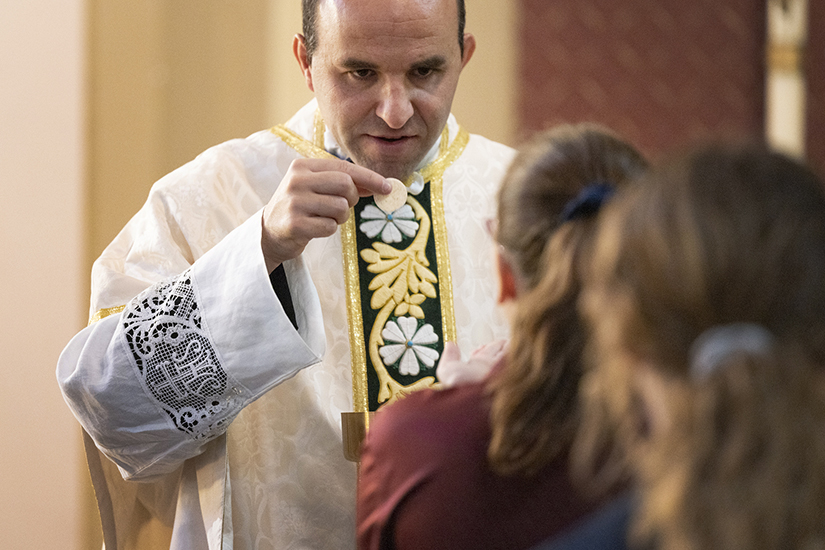 Father Eddie Godefroid, associate pastor at St. Charles Borromeo, distributed the Eucharist at Mass on All Saints’ Day Nov. 1 at the church in St. Charles. Father Godefroid, who was ordained in 2021, said of his priesthood: “The thing that sticks out most is how God, how His grace is always sufficient for us. He throws challenges at us, but He always gives us the strength to persevere.”