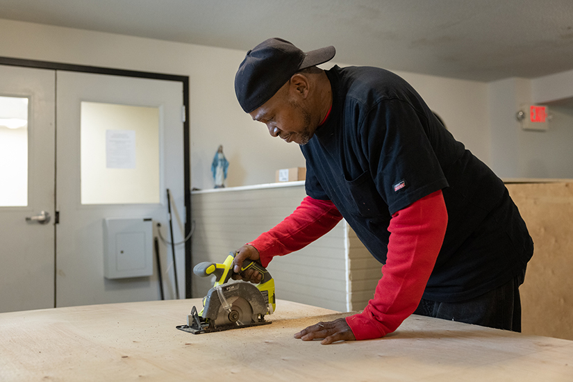Gary Walker, facilities manager at McFarlane Place, cut boards to place over windows Dec. 2 at St. Patrick Center’s McFarlane Place apartment building in St. Louis.