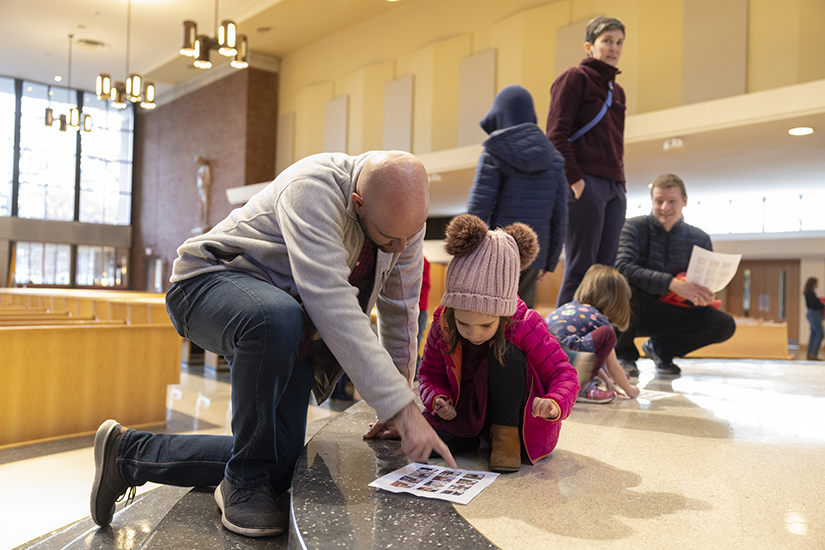 Eric Jones and his daughter, Eleanor Jones, 4, looked for items in a church seek-and-find activity Dec. 4 at St. Peter Church in Kirkwood. The activity had families searching for various items in the church such as a tabernacle, paschal candle and statue of St. Louis.