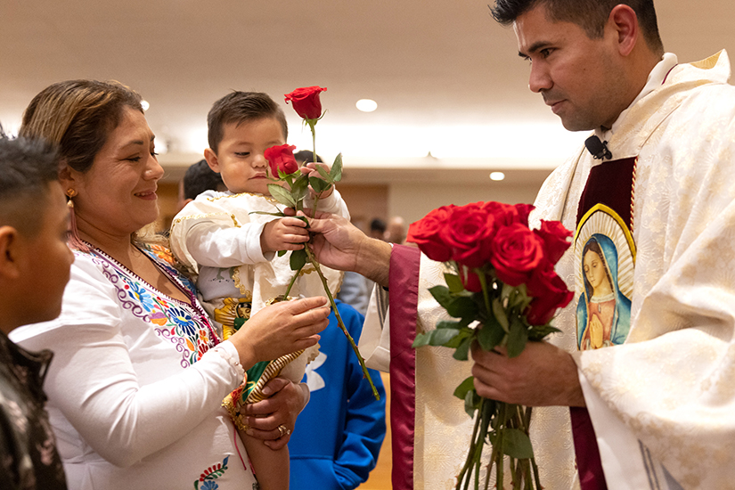 Delia Bernar and her son Gael Rojas accepted roses from Father Gerson Parra on the Feast of Our Lady of Guadalupe on Dec. 12 at St. Patrick Church in Wentzville. Father Parra said the roses represent those Our Lady of Guadalupe gave to Juan Diego. “She’s a mom. … You can go to Mexico from north, south, east and west and she is present over all the nation,” Father Parra said.