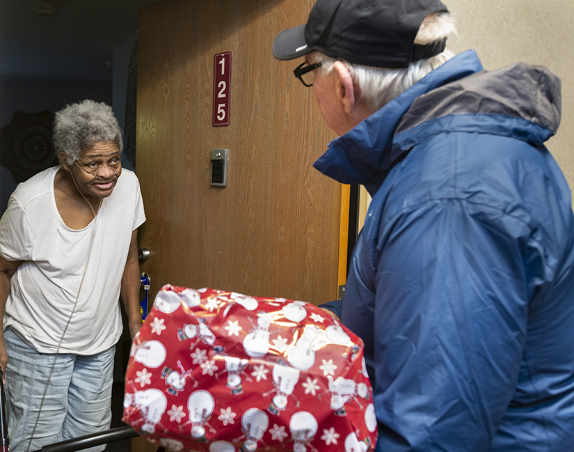 Betty Thomas, left, received gifts and food Dec. 15 from Bob Buck, a member of the Men’s Group at Ascension parish in Chesterfield. The group distributed goods to seniors living in poverty at Alexian Court Apartments.