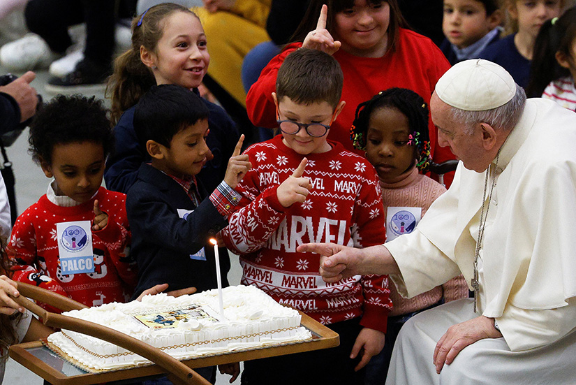 Pope Francis received a cake for his 86th birthday during an audience with children and volunteers of the Vatican’s St. Martha Dispensary, a maternal and pediatric clinic, at the Vatican Dec. 18.