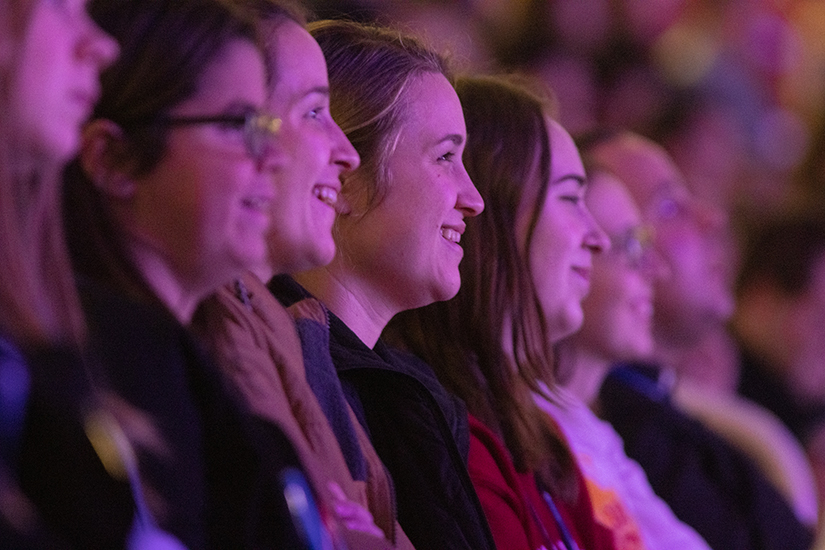 Chelsea Maag of Maryville University, center, and her sister Michelle Maag of Illinois College, left of her sister, listened to Father Mike Schmitz speak to the crowd during day two of SEEK23 on Jan. 3 at America’s Center Convention Complex in St. Louis. 