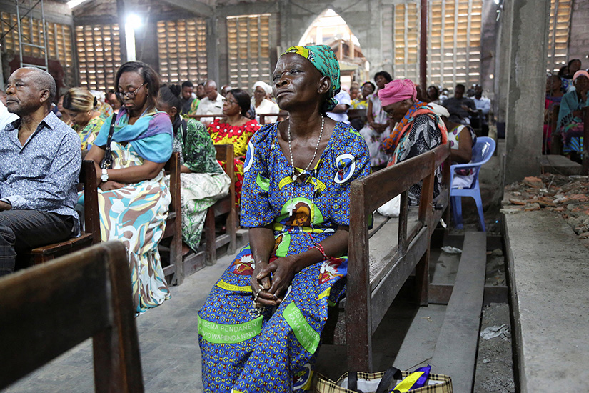 A woman listened to the the homily during morning Mass at St. Charles Church in Kinshasa, Congo, Jan. 22. In his homily, Father Abbe Victor Ntambwe, pastor, encouraged parishioners to be sensitive in the electoral process. Pope Francis is scheduled to visit Kinshasa Jan. 31-Feb. 3.