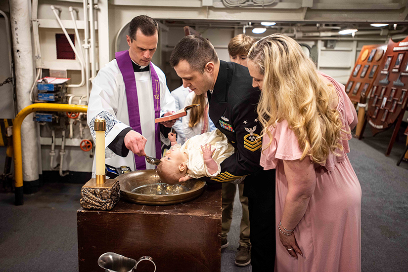 Father David Miloscia baptized Amelia Hensley held by Master Chief Machinist’s Mate (Nuclear) Justin Hensley aboard the USS Ronald Reagan.
