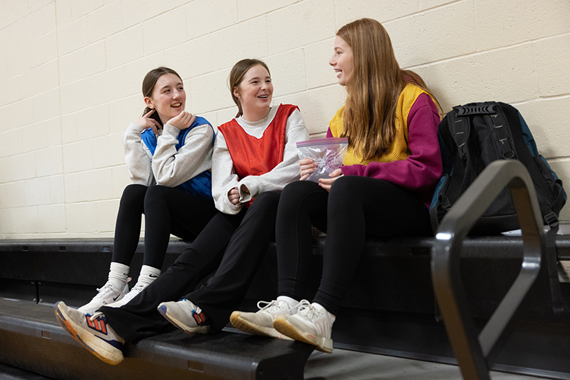 Holy Cross Academy seventh-graders, from left, Tess Jackson, Anna Krueger and Kate Mealey talked during a gym period Jan. 30 at the Annunciation Middle School Campus of Holy Cross Academy in Webster Groves.