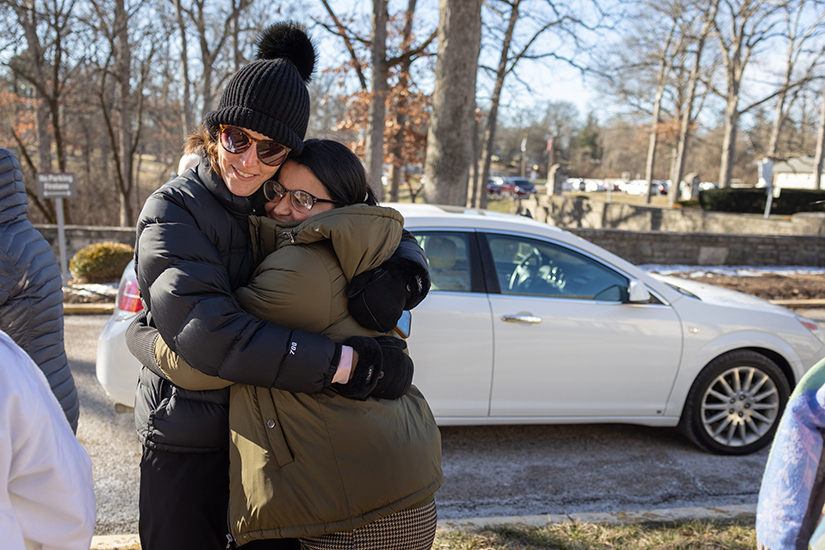 Freshta Zary, right, hugged Katie Schwaneke, who works with HumanKind STL and is a parishioner at St. Clement of Rome in Des Peres, shortly after a car was presented to Zary at Villa Duchesne in Frontenac. Catholic Schools Week fundraising efforts by Villa Duchesne students raised money to support the Zary family.
