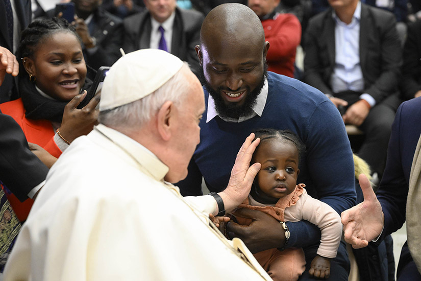 Pope Francis blessed a child after his weekly general audience in the Vatican audience hall Feb. 15.