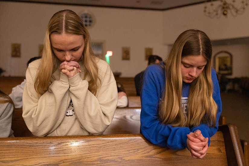 Bella Obert, left, and Sophie Maupin, both parishioners at Immaculate Conception in Dardenne Prairie, prayed during adoration at a Eucharistic Revival Youth Rally on Feb. 17 at Ascension Church in Chesterfield. About 100 teens and adults attended the youth event, which included praise and worship music, eucharistic adoration and opportunities for confessions and healing prayer.
