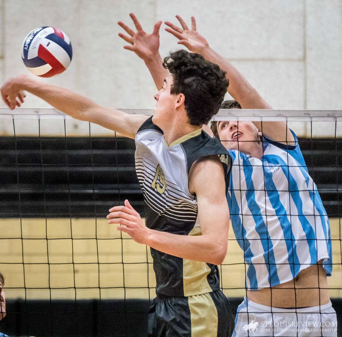 St. Louis University High School’s #12, Andrew Cross, tried to block the ball at the net against Lafayette’s Chris Harstick. St. Louis University High School Billikens beat Lafayette High School Lancers 2-3 to win the Class 4 Volleyball state championships.