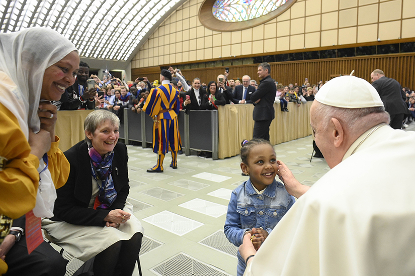 Pope Francis greeted a child during an audience with hundreds of refugees and displaced people and with those who have assisted them at the Vatican’s Paul VI audience hall March 18.