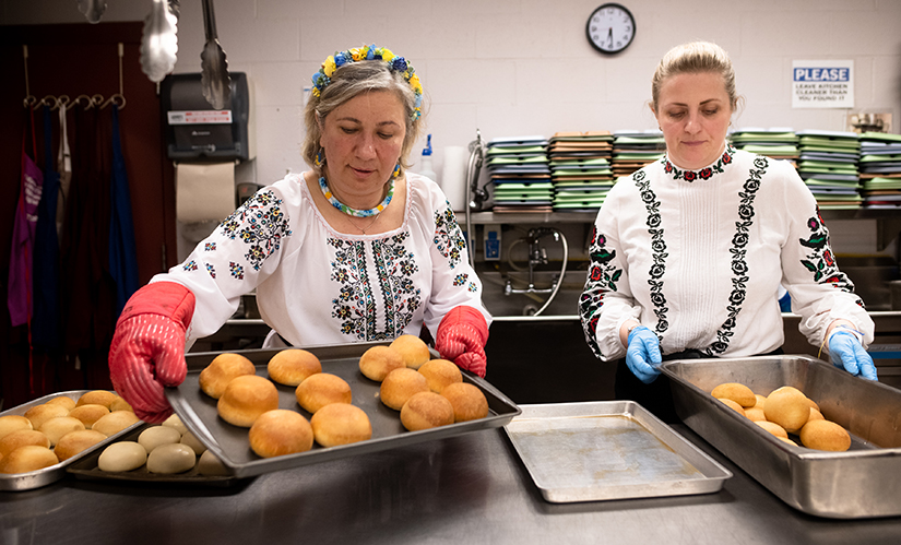Tetiana Mouzi of St. Mary’s Assumption Ukrainian Catholic Church and Nataliia Lazar of St. George Ura Catholic Church in Ukraine took out bread rolls from the oven on April 22 at St. Justin Martyr Parish in Sunset Hills. Lazar fled Ukraine with her 16-year-old daughter, Lina Lazar, and has been supported by St. Mary’s Assumption Parish.