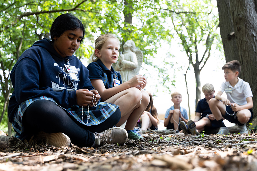 Reya Sathish and Sadie Husmann prayed the Rosary in the Our Lady’s Prayer Garden during the spring day of faith May 18 at Immaculate Conception School in Dardenne Prairie.