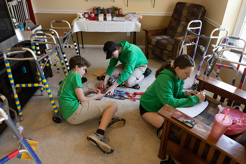 Kyle Newman, Josh Diehl and Aubrey Davis, all eighth-graders at Christ Prince of Peace School in Manchester, worked on decorative accessories for walkers April 3 at Josh’s home in Manchester.