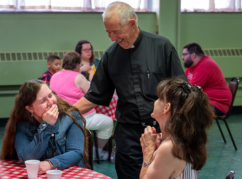 Father Phillip Krill talked with parishioners Jessica Parrott, left, and Cathy Parrott during a community barbecue following the final Mass at St. Andrew Parish in Lemay July 30. On Aug. 1, most parish changes from All Things New took effect.
