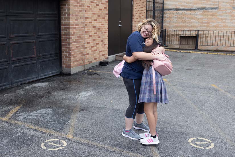 Mary Meier, a Spanish teacher at St. Cecilia School and Academy, hugged third-grader Kerlyn Daleyza Santana on the first day of the school year on Aug. 14 at St. Cecilia School and Academy in south St. Louis.