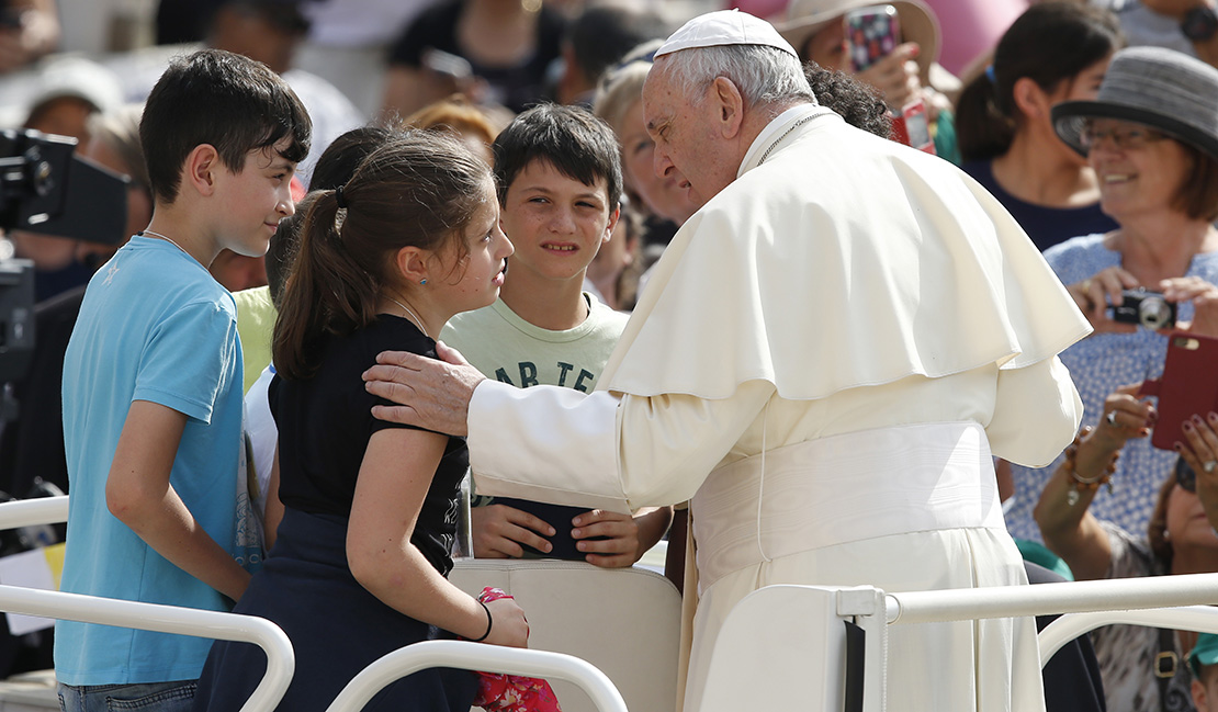 Pope Francis talked with children who rode in the popemobile during his general audience June 6 in St. Peter’s Square at the Vatican.