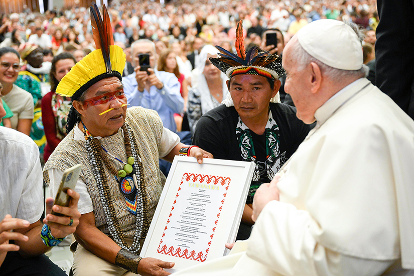 Pope Francis received a framed copy of the Lord’s Prayer in the language of the Yawanawá people of Brazil at the end of his weekly general audience in the Paul VI Audience Hall at the Vatican Aug. 23.