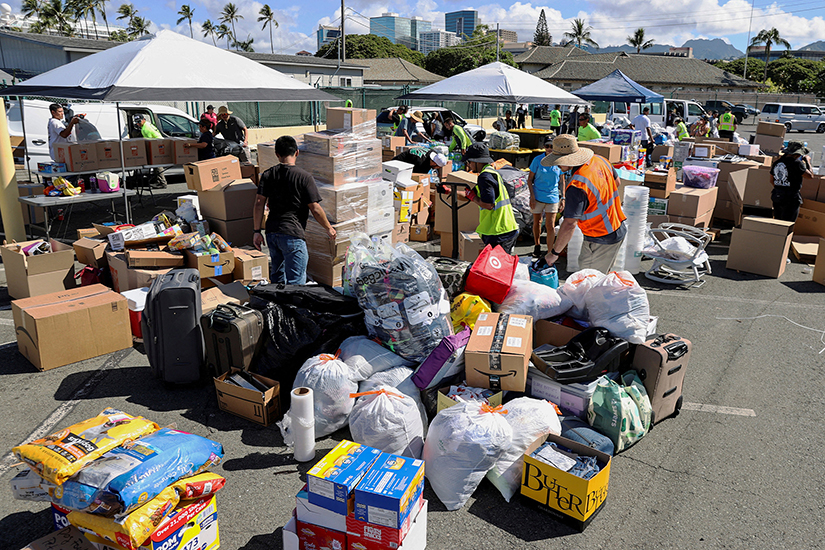 Volunteers prepared donations for the victims of the Maui wildfires at Pier 1 in Honolulu Aug. 12. The devastating wildfires on Maui have claimed over 100 lives, and more than 1,000 missing, and burned thousands of homes, businesses and historical sites, leaving locals desperate for basic necessities including food, water and housing.