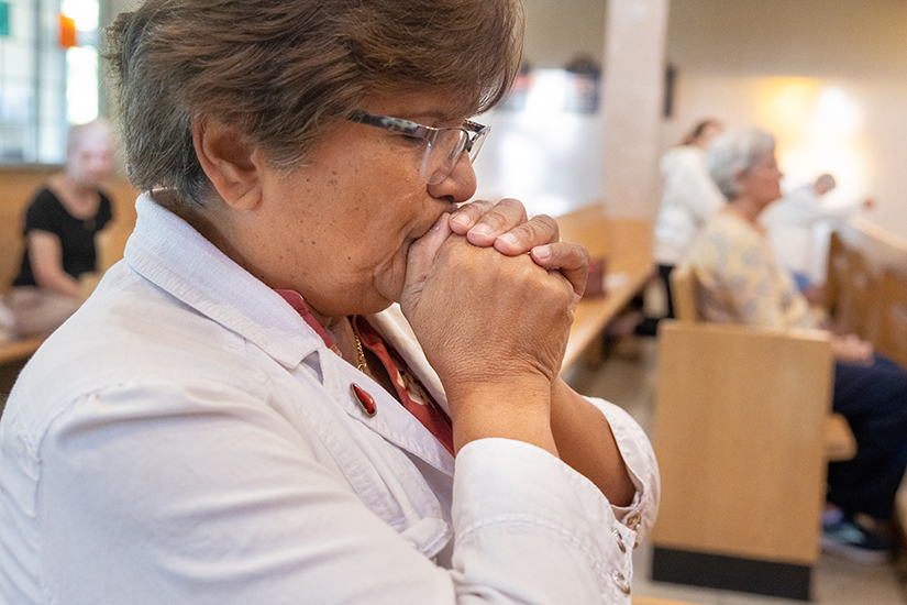 Marisol Pfaff knelt during a morning Mass on Aug. 30 at St. Joan of Arc Church in St. Louis. Pfaff had two abortions decades ago. “We need to really open our hearts and really reach out to people because there is a lot of pain and suffering out there,” Pfaff said. “God forgives everything.”