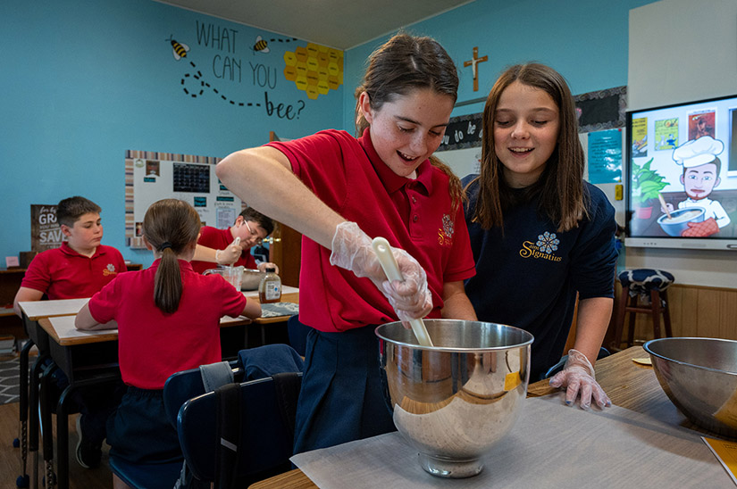 St. Ignatius of Loyola School sixth graders Emma Poindexter, left, and Gracie Koch combined ingredients for Lebkuchenherzen (Oktoberfest Gingerbread Hearts) during German class Sept. 19. Teacher Jacob Lierman weaves culture, traditions and geography into the class alongside learning the language at the school, which has a long German heritage.