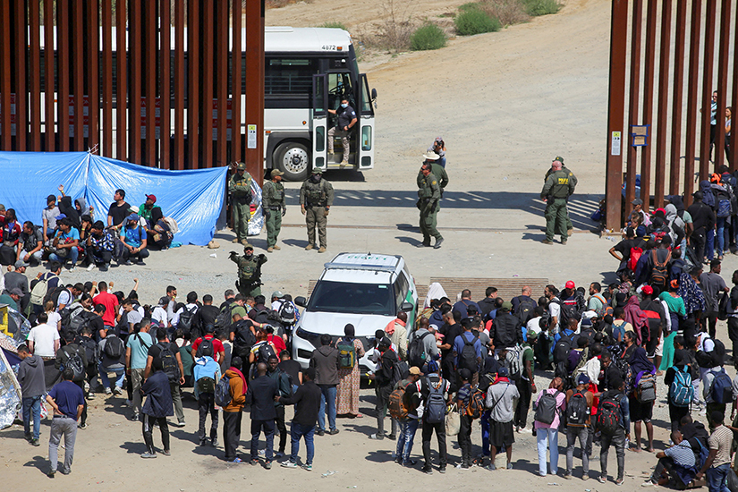 Migrants gathered Sept. 13 between the primary and secondary fences at the U.S.-Mexico border near Tijuana, Mexico, as they waited to be processed by U.S. Border Patrol agents.
