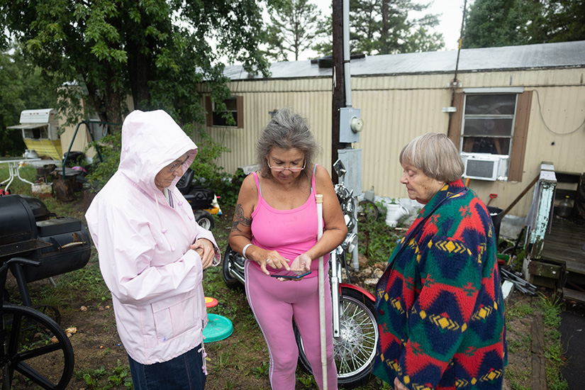 Rural Parish Workers of Christ the King Natalie Villmer, left, and Neva Calvert, right, met with Virginia Bannister outside her home July 19 in Washington County. Virginia was having roof issues at the home, and the Rural Parish Workers were seeing what assistance they could provide.