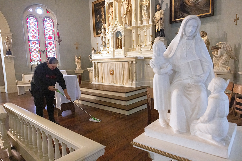 Jennifer Long, with BELFOR Property Restoration and a parishioner at Sts. Peter and Paul in Collinsville, Illinois, cleaned floors Oct. 20 near a statue of St. Rose Philippine Duchesne, who lived at Old St. Ferdinand Shrine in Florissant in the 1800s. The shrine was damaged by flooding in July 2022 and will have a new altar dedicated on Nov. 18.