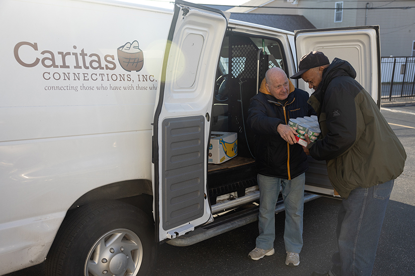 Caritas Connections volunteer Gary Behrens, a parishioner at St. Gerard Majella in Kirkwood, unloaded goods with the assistance of Eddie Griffin of St. Louis on Oct. 31 outside St. Nicholas St. Vincent de Paul food pantry, now part of St. Josephine Bakhita Parish in north St. Louis.