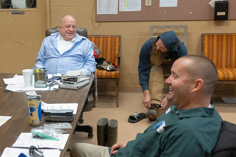 Tom Kuehner, left, managing director of grounds and facilities for Catholic Cemeteries of the Archdiocese of St. Louis, laughed with employees Darris Spilker, center, and Mark Feldmann before the group parted ways for assorted tasks Nov. 2 at Calvary Cemetery in north St. Louis.