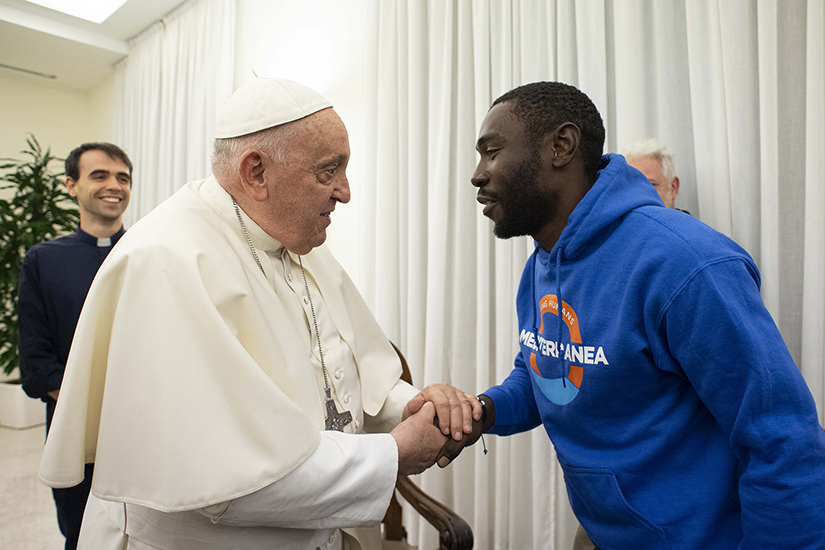 Pope Francis greeted Mbengue Nyimbilo Crepin, a migrant from Cameroon during a meeting in the Domus Sanctae Marthae at the Vatican Nov. 17. The pope said he has been praying for Crepin since July when his wife and daughter died crossing the North African desert.