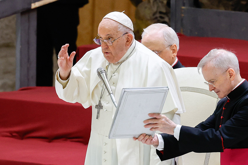 Pope Francis gave his blessing at the end of his weekly general audience as Msgr. Luis Maria Rodrigo Ewart, an aide, held the pope’s prayer book in the Paul VI Audience Hall at the Vatican Dec. 13.