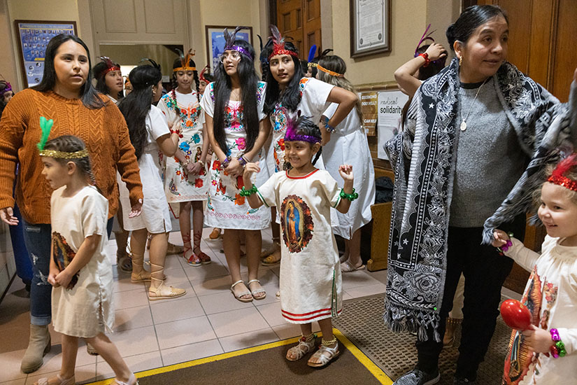 Five-year-old Genesis Rosales, center, a parishioner at St. Charles Borromeo, waited to take part in a danza de los matachines (folkloric dance) for the feast day celebration of Our Lady of Guadalupe on Dec. 11 at St. Charles Church in St. Charles. The feast day celebrations included activities such as danza de los matachines (folkloric dance), a play of Mary’s apparitions, dinner, fellowship and Mass on Tuesday evening.