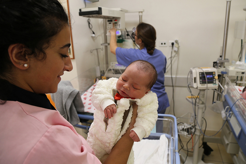 A woman is pictured in a file photo holding a newborn at Holy Land Family Hospital of Bethlehem in the West Bank. The hospital is confronting significant challenges amid the ongoing war between Israel and Hamas in the Gaza Strip 45 miles away.