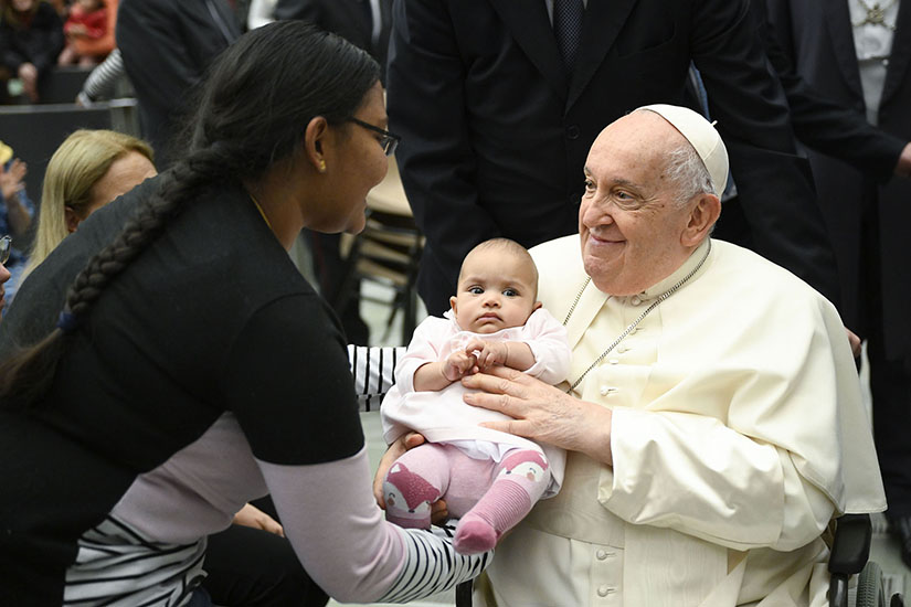 Pope Francis held an infant after his weekly general audience in the Paul VI Audience Hall at the Vatican Jan. 3.