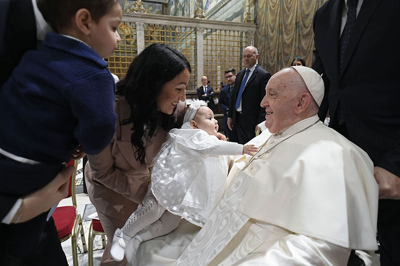 A baby reached out to Pope Francis after he baptized her during Mass in the Sistine Chapel at the Vatican Jan. 7, the feast of the Baptism of the Lord.