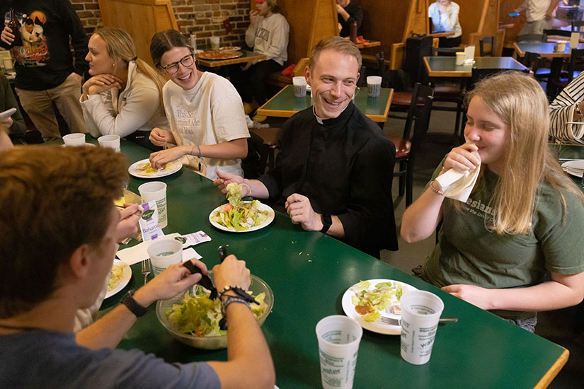 Father Andrew Auer’s ministry at the University of Missouri frequently leads him to socialize with students. Father Auer shared a meal at Shakespeare’s Pizza in Columbia with University of Missouri students, from right, Olivia Evers, a parishioner at Assumption in south St. Louis County; Julia Boessen, a parishioner at Sacred Heart in Troy; and Abby Obert, at parishioner at Immaculate Conception in Dardenne Prairie.