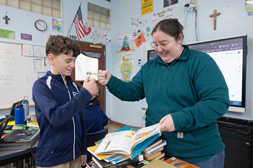 St. Gabriel the Archangel sixth-grader Liam Rolwes fist bumped social studies teacher Claire Brennecke while talking about a Greek mythology project Feb. 12 at the school in St. Louis. Liam received a “Help for Today, Hope for Tomorrow” scholarship from the Today and Tomorrow Educational Foundation.