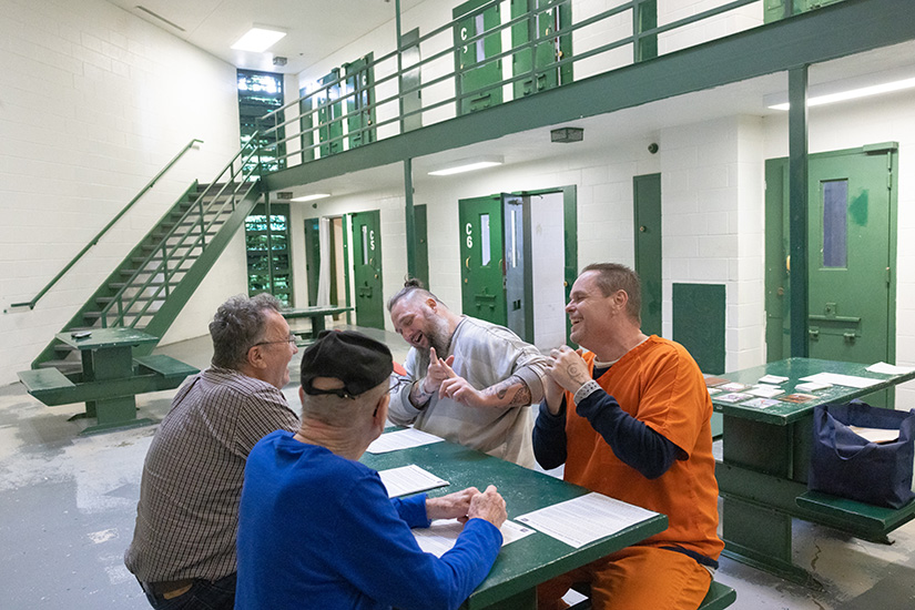 Perry County Jail inmates James Tiller, rear, and Charles Blakey, right, laughed while taking part in a Bible study with Mark Renaud, left, and John Gahan Feb. 27 at the Perry County Jail in Perryville. Renaud and Gahan are part of a group of volunteers with the Society of St. Vincent de Paul at St. Vincent de Paul Parish in Perryville who visit the jail twice a month for Bible study.