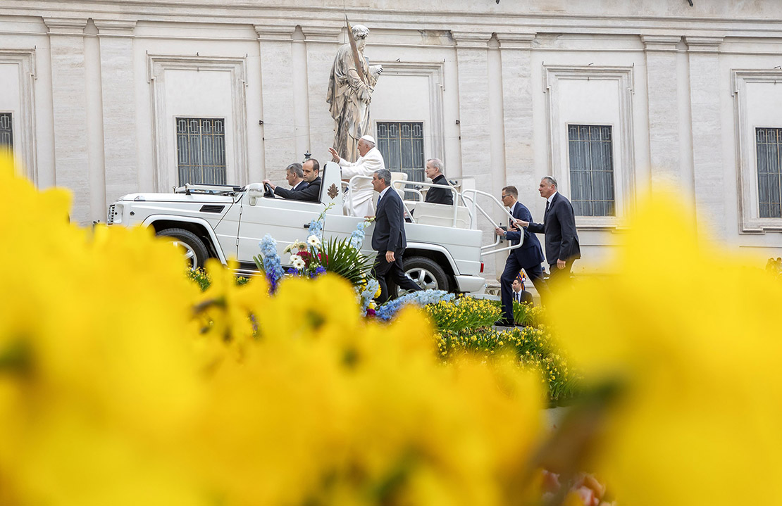 Pope Francis rode in the popemobile past Easter flowers in St. Peter’s Square for his weekly general audience April 3.