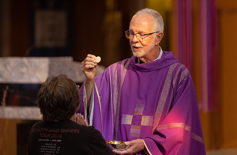 Father Michael Henning distributed the Eucharist at Mass on March 6 at St. Joan of Arc Church in St. Louis. The Annual Catholic Appeal supports retired priests like Father Henning.