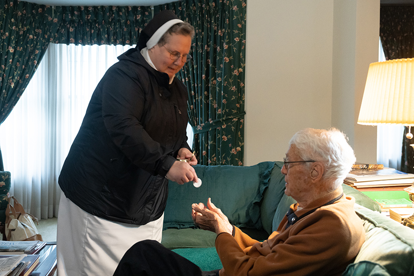 Sister Sandra Krupp, ASCJ, brought the Eucharist to Ray Farina at his home on April 2. Sister Sandra ministers to homebound St. Ambrose parishioners, bringing them the Eucharist, updating them on parish happenings and visiting with them