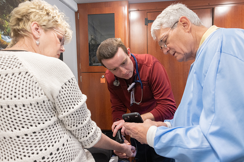 Dr. Tom Johans, right, and Dr. Noah Brown examined a bump on Rhonda Neel of Festus with an ultrasound machine April 4 during the Rural Parish Clinic medical clinic’s stop outside the Peace Pantry in Cedar Hill. The Rural Parish Clinic is marking its fifth anniversary in 2024.