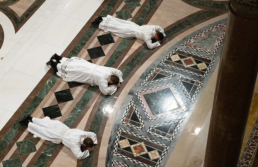 Jeff Fennewald, Robert Lawson and Joe Martin prostrated themselves during their ordination to the transitional diaconate at the Cathedral Basilica of Saint Louis in 2023. They anticipate ordination to the priesthood on May 25.