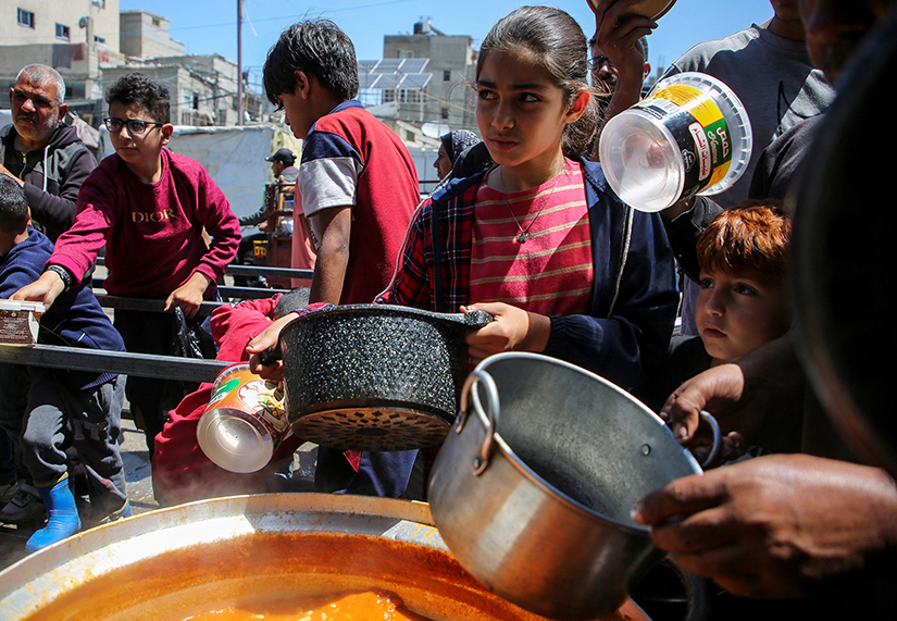 Palestinian children gathered to receive food cooked by a charity kitchen, amid shortages of aid supplies, after Israeli forces launched a ground and air operation in the eastern part of Rafah in the southern Gaza Strip May 8.